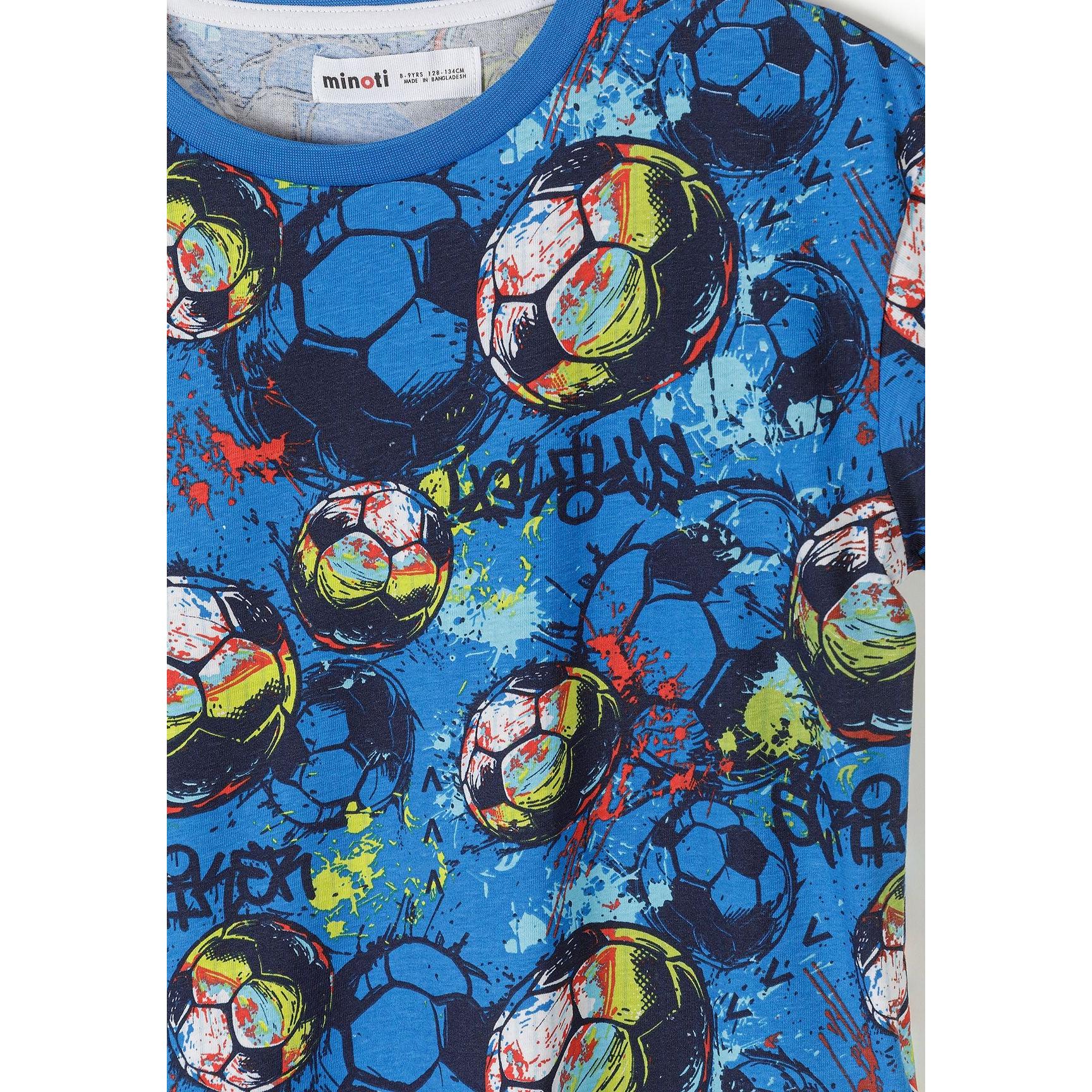 Close-up detail of blue football print t-shirt showing Minoti label and colorful soccer balls with paint splatter effect in blues, greens, reds and yellows