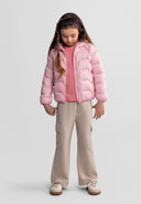 Young girl wearing a lightweight pink hooded jacket with beige pants, showcasing a stylish and cozy design for kids.