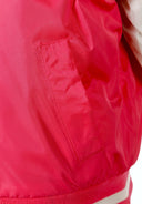 Close-up of lightweight pink varsity jacket pocket with detailed stitching and fabric texture design