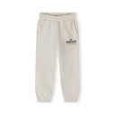 Girls' off-white cotton-polyester joggers with elasticated waist, side pockets, cuffed ankles, and "LE MARAIS" print.