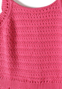 Close-up of a breathable pink crochet fabric with intricate stitch patterns and adjustable strap design for girls.