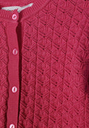 Close-up of pink slim fit girls cardigan with textured geometric knit design and button-up front detail