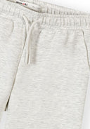 Close-up of girls grey wide leg joggers with elasticated waist, drawstring, and side pockets featuring soft mottled design.