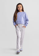 Young girl modeling light grey wide leg joggers with elasticated waist paired with a lilac sweatshirt in kids fashion style