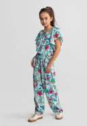 Girl wearing a mint-colored tropical print viscose set with ruffle sleeves and floral design in a relaxed pose