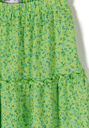 Close-up of green floral print fabric with elasticated waistband and ruffled design detail for girls' skirt.