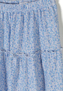 Close-up of a blue floral patterned fabric with elasticated waistband and detailed ruffle design for girls maxi skirt.