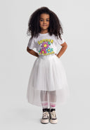 Girl wearing off-white pleated maxi tulle skirt paired with casual summer-themed graphic t-shirt and sneakers