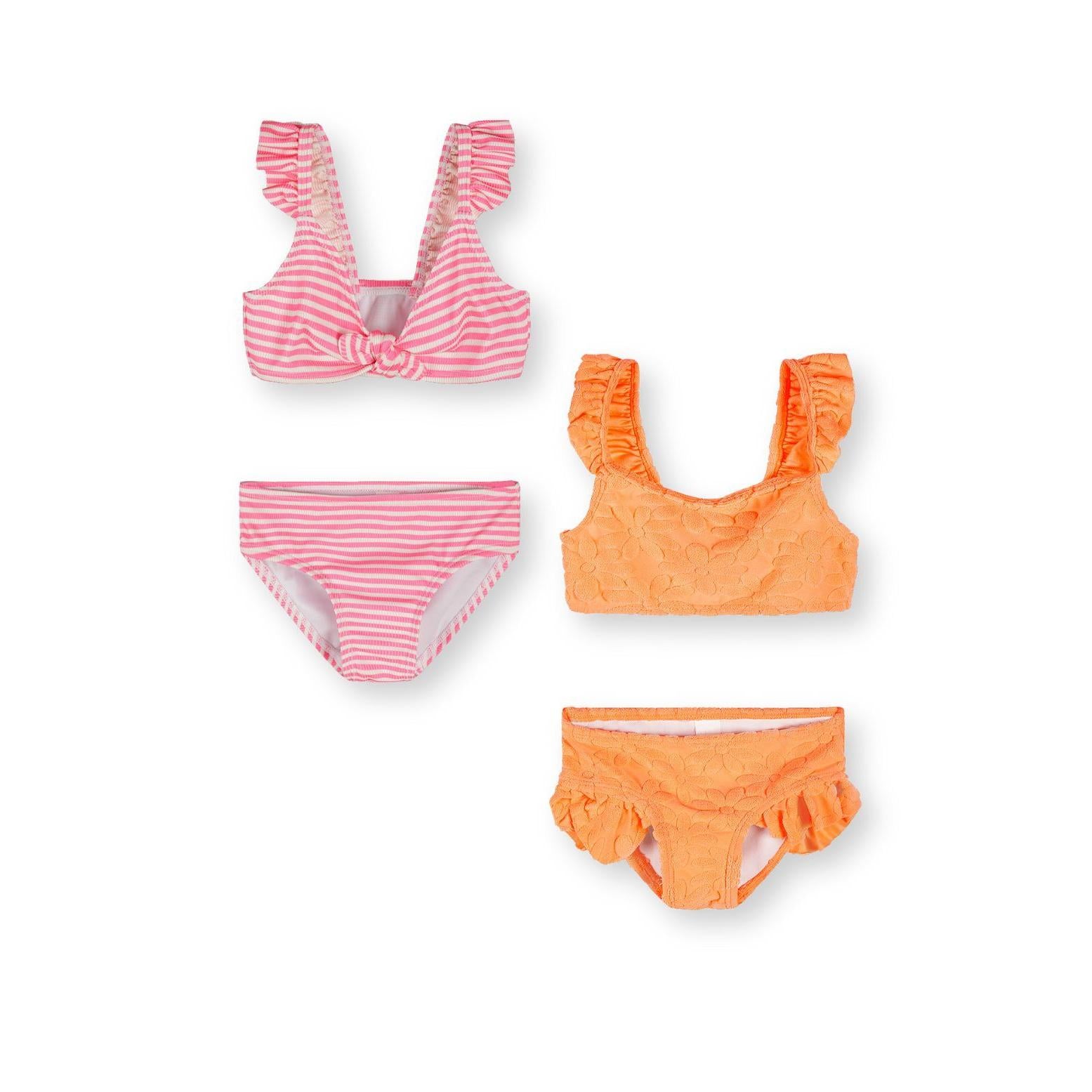 Pink and orange bikini sets laid flat on white background showing striped pink bikini top and bottoms alongside orange textured bikini pieces with frill details
