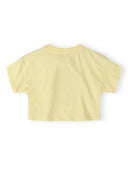 Back view of a pale yellow short sleeve cotton t-shirt for girls, featuring a simple and clean design.