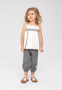 Girls embroidered top and gingham trousers cream 3m-3y. Flared woven fabric top with frilled straps and embroidery paired with black and white gingham harem-style trousers.