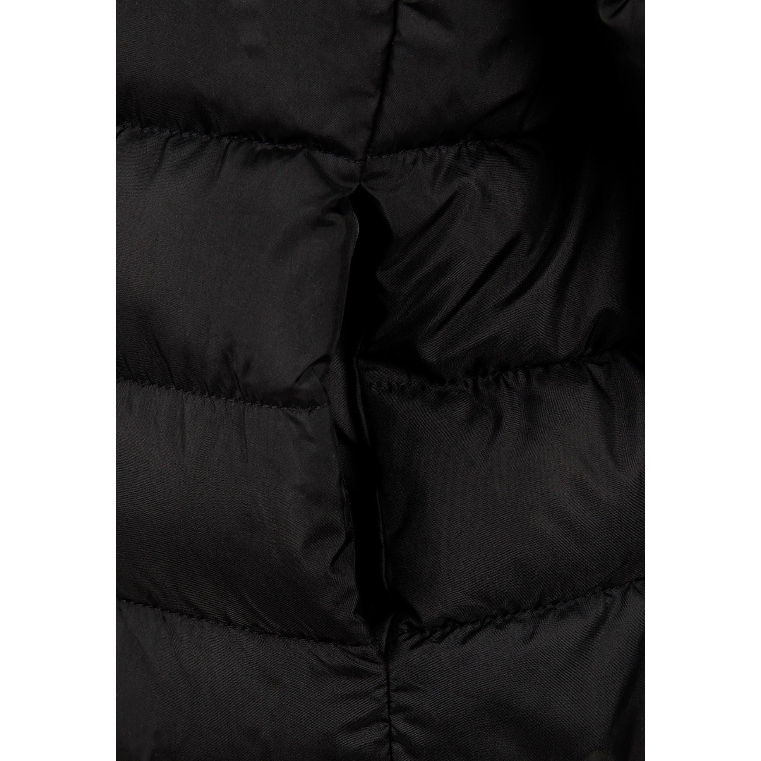 Detail view of black quilted jacket sleeve showing padded construction and embossed circular Minoti logo patch