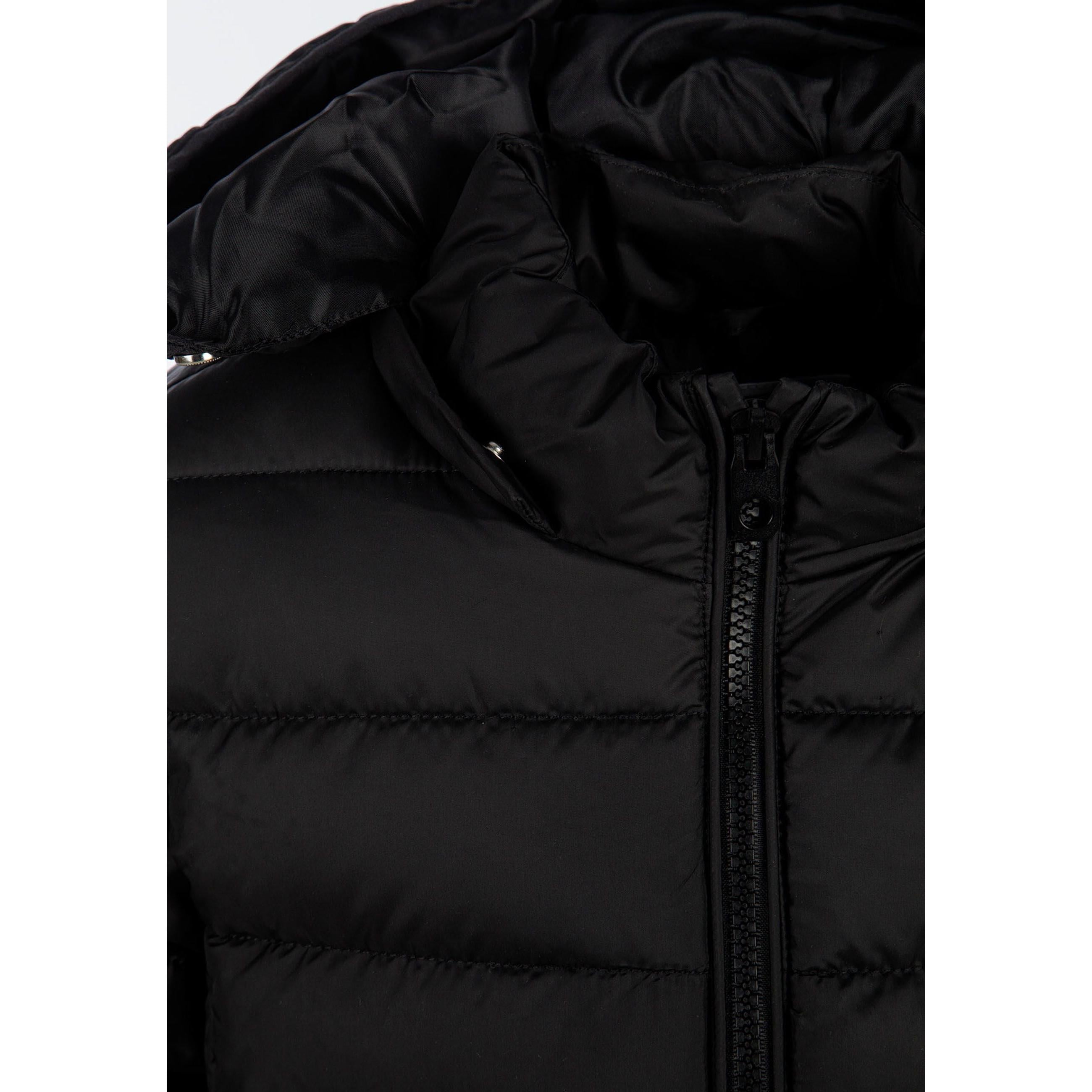 Detail view of black quilted jacket sleeve showing padded construction and embossed circular Minoti logo patch