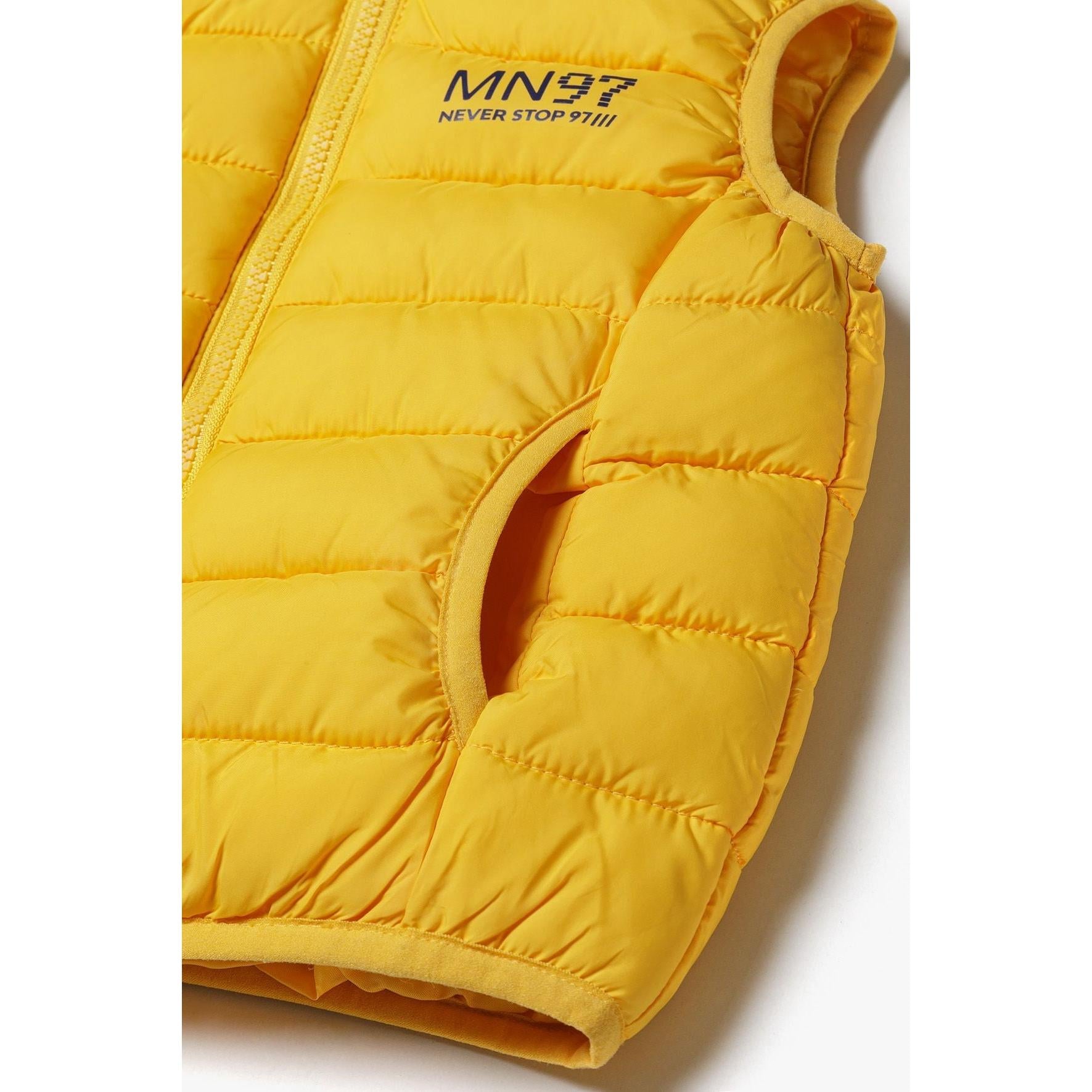 Close-up detail of yellow padded gilet showing zip opening, Minoti label and MN97 Never Stop branding print