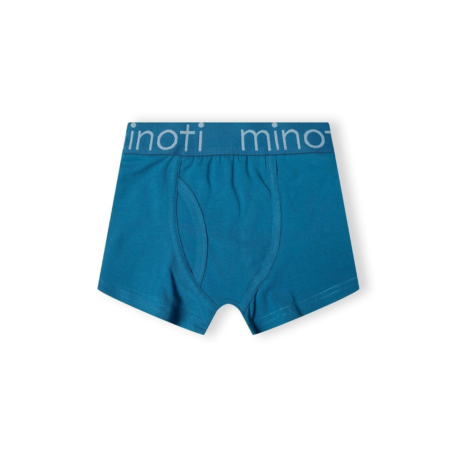 Single medium blue trunk with branded elastic waistband featuring Minoti logo, front view on white background showing classic fit