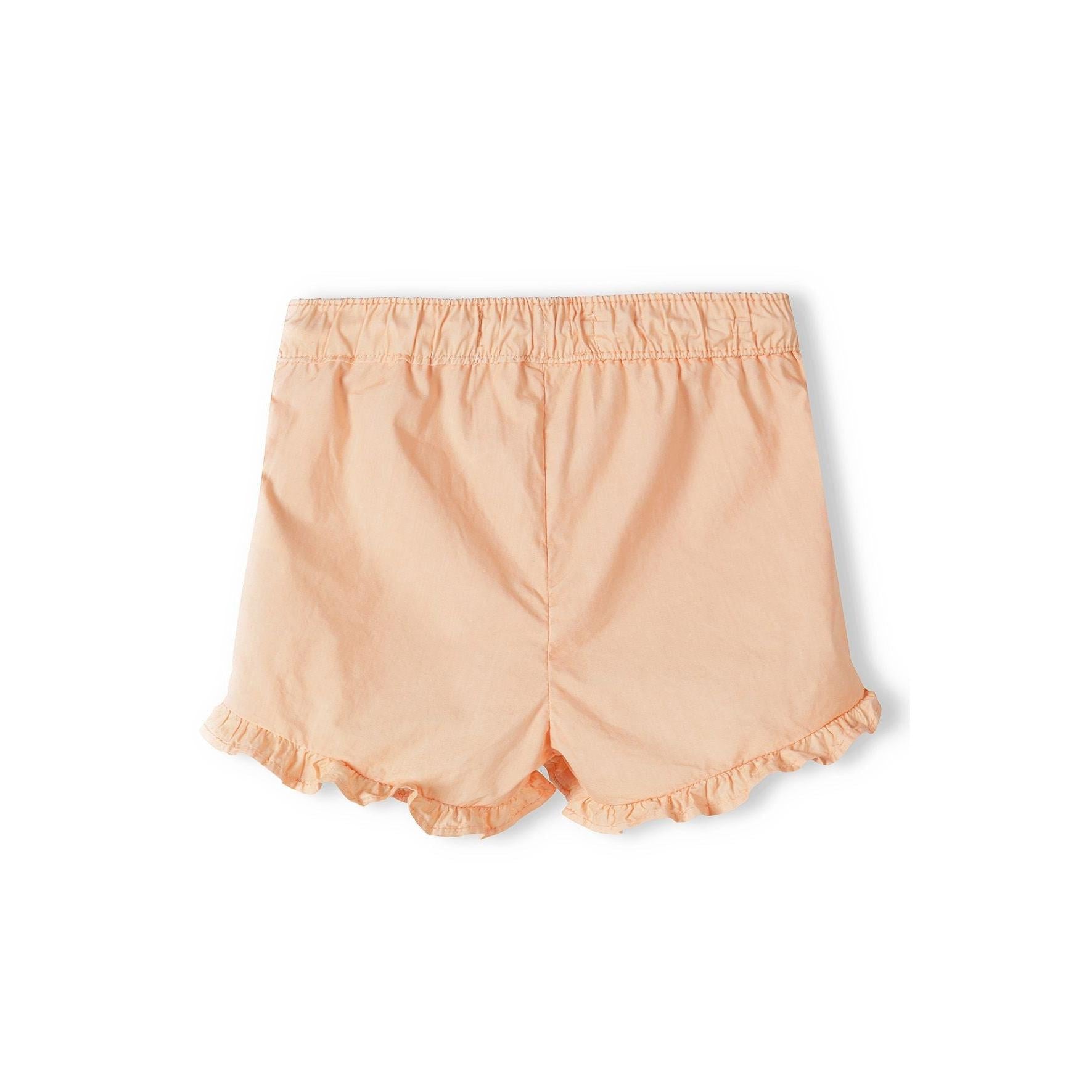 Back view of orange poplin shorts showing elasticated waistband and frill trim hem detail on white background