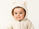 Soft cream-colored fleece onesie with adorable bear ear hood.