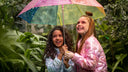 A vibrant, multi-colored umbrella with a translucent canopy featuring pink, blue, green, and yellow sections.
